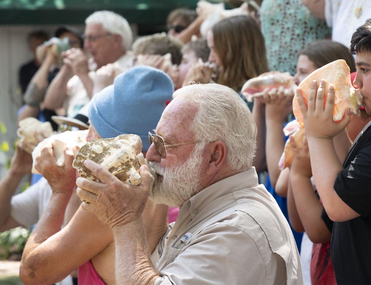 People blowing into Conch Shells